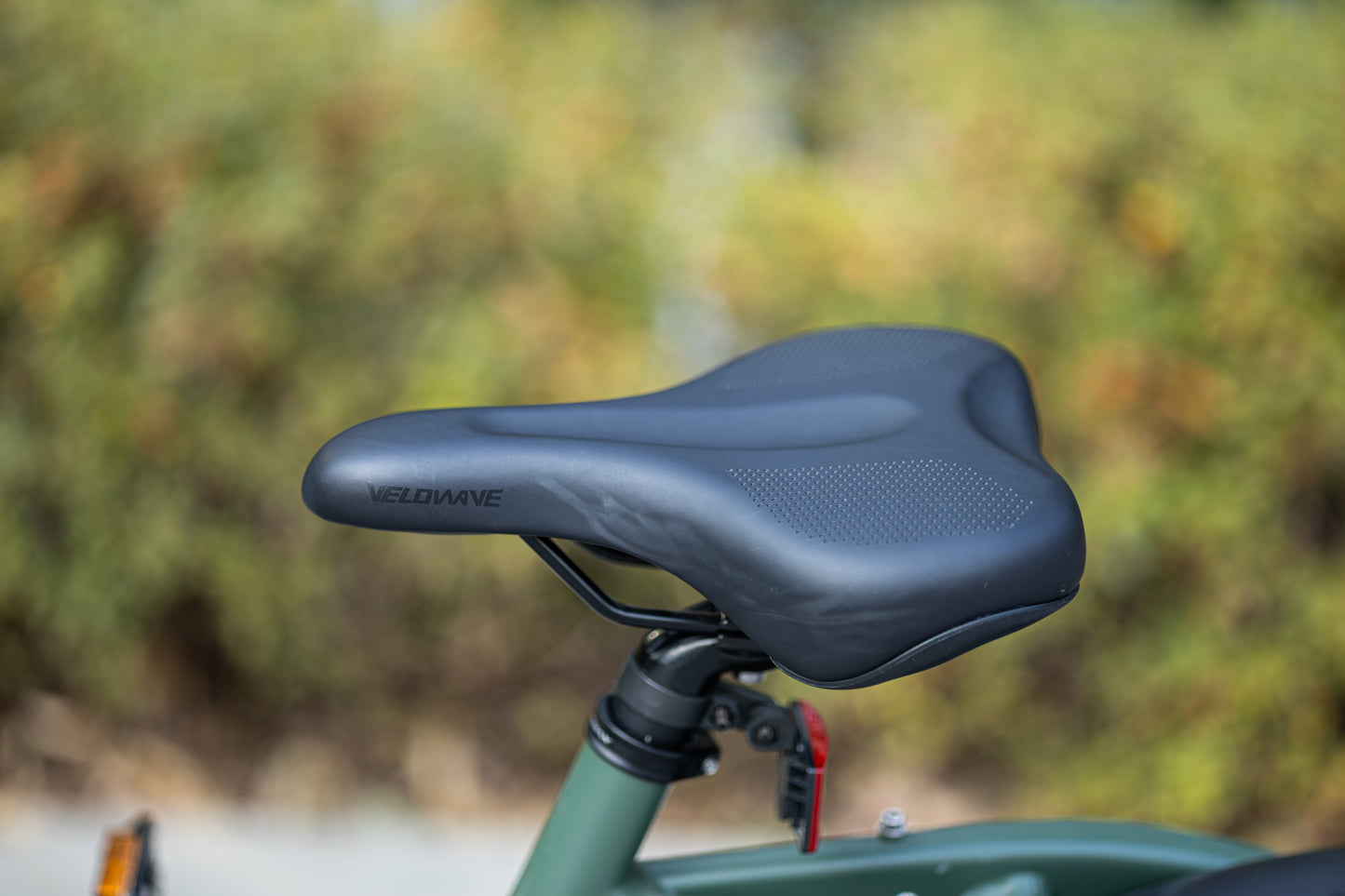 velowave_Close-up of the Pony electric bicycle seat with blurred greenery in the background