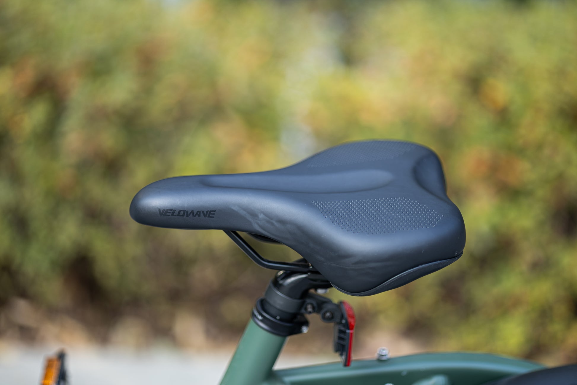 velowave_Close-up of the Pony electric bicycle seat with blurred greenery in the background