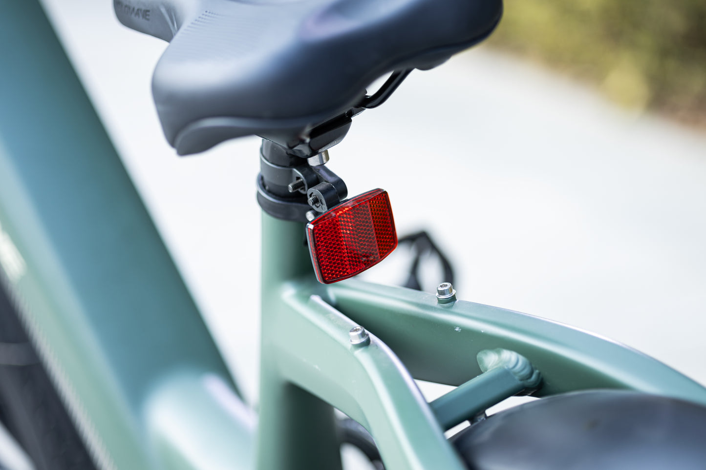 velowave_Green bicycle taillight attached to a green bike frame with a blurred background