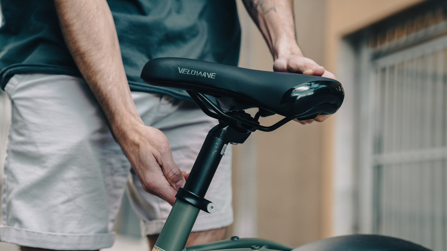 velowave_Person adjusting a Pony electric bicycle seat with 'VeloWave' branding.