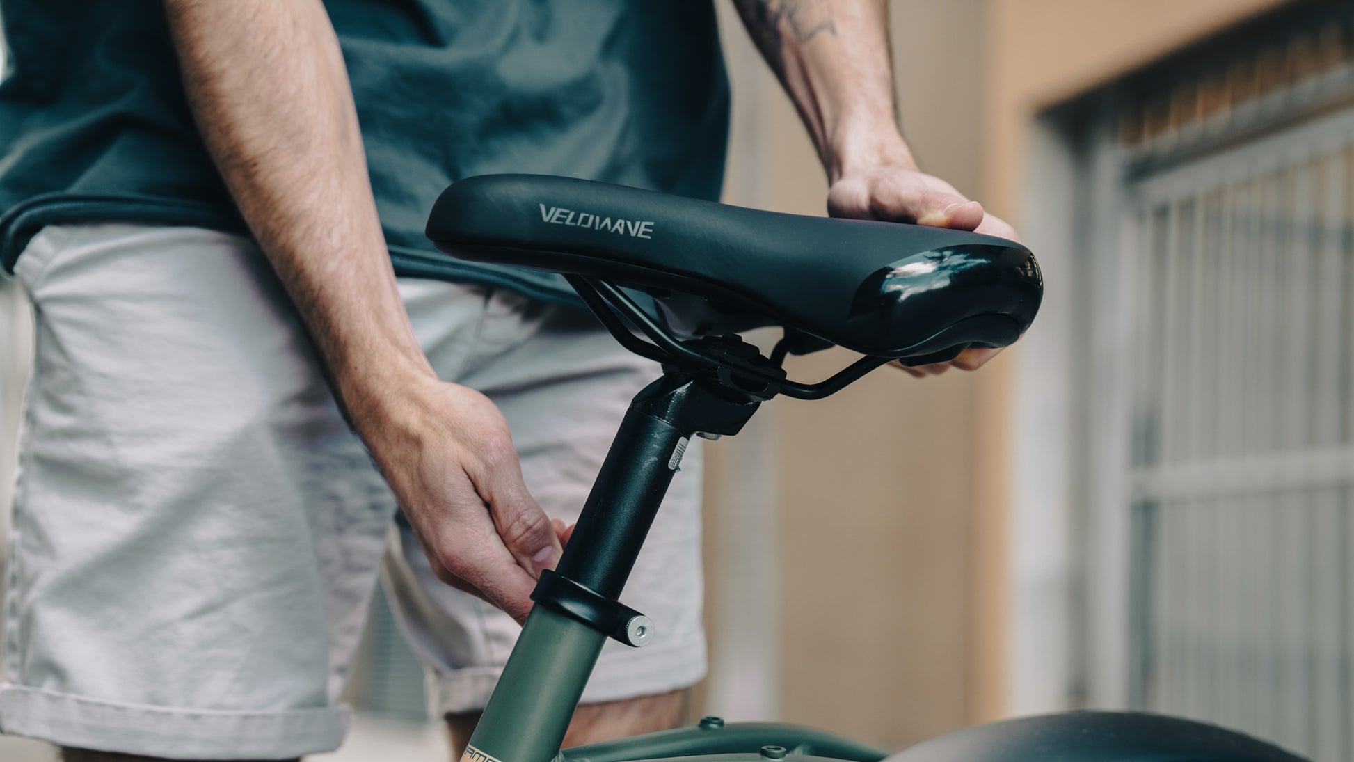 velowave_Person adjusting a Pony electric bicycle seat with 'VeloWave' branding.