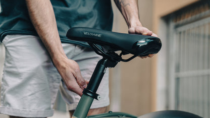 velowave_Person adjusting a Pony electric bicycle seat with 'VeloWave' branding.