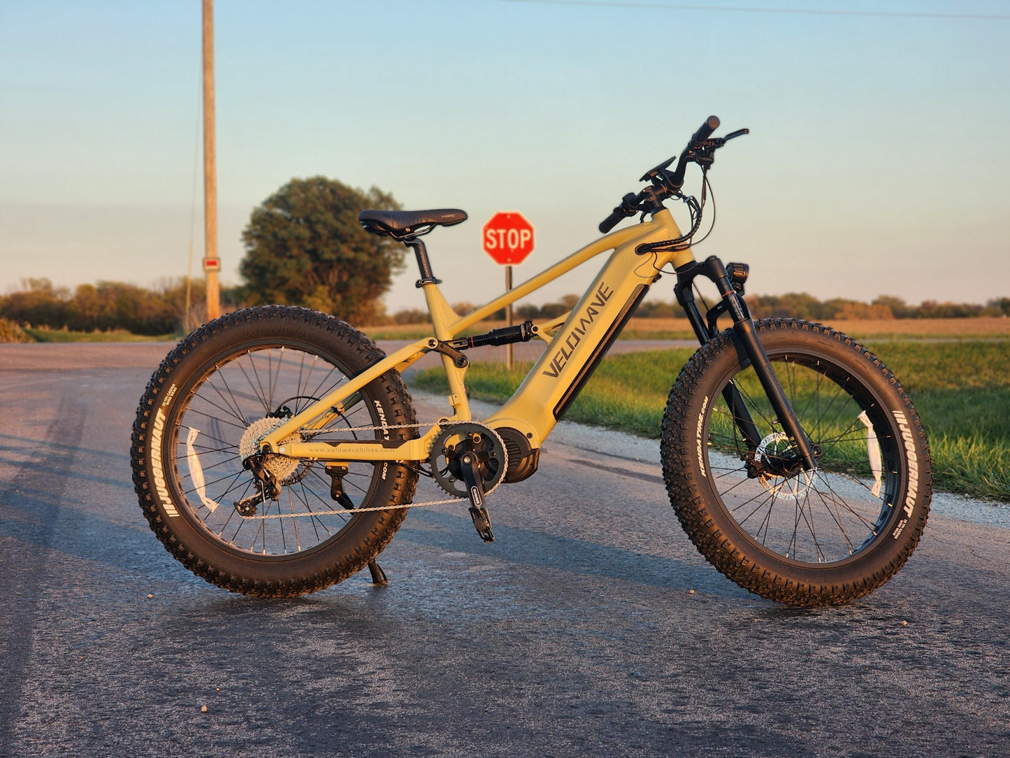 velowave_Olive Green electric bike on a road with a stop sign in the background – BrawnyXM Showcase