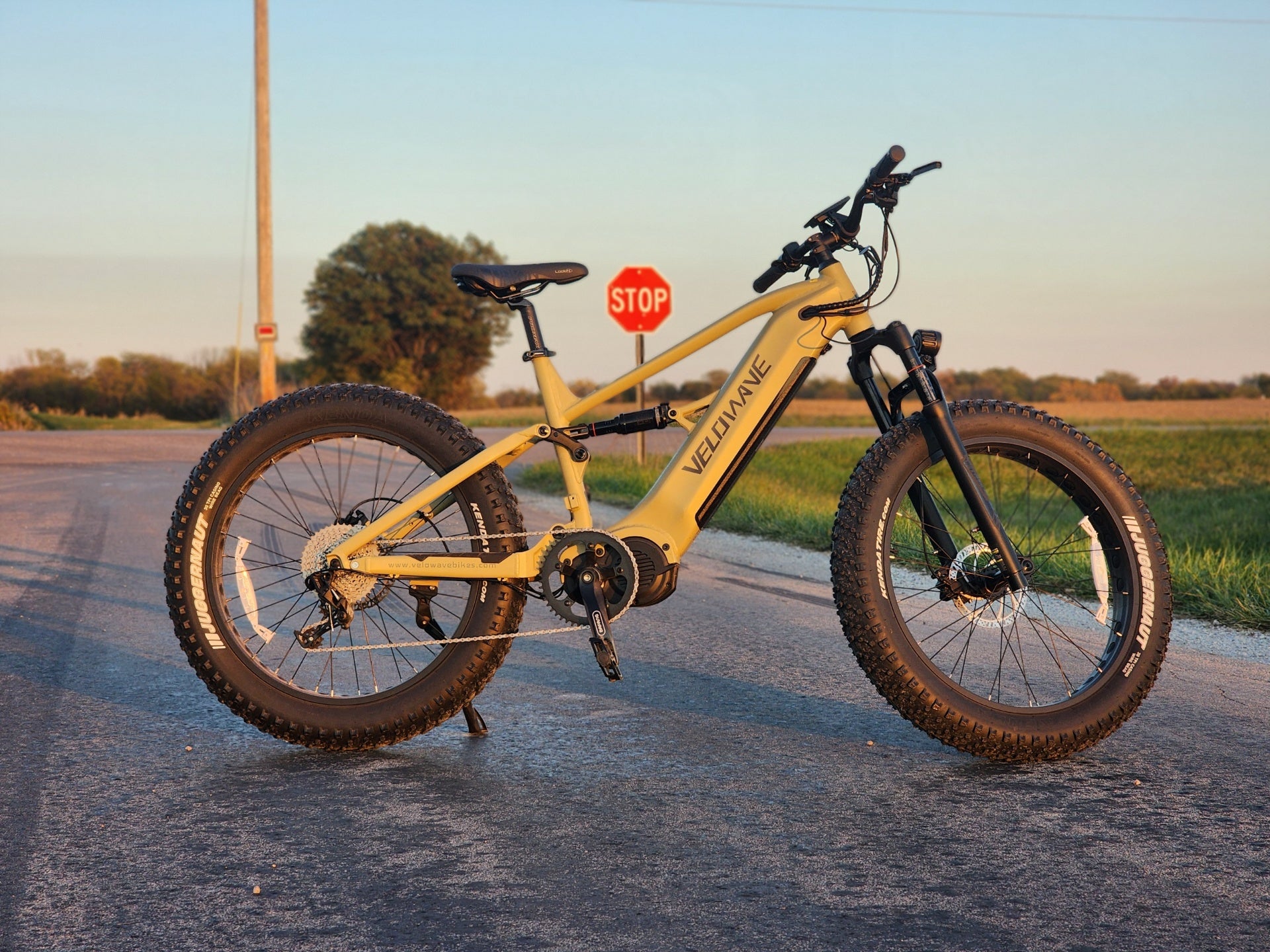velowave_Olive Green electric bike on a road with a stop sign in the background – BrawnyXM Showcase