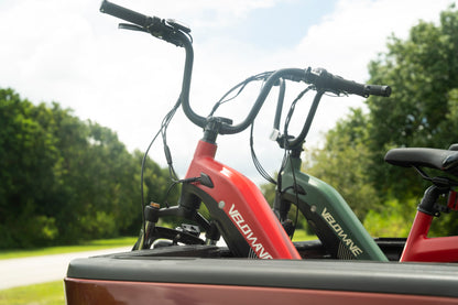 velowave_Two Pony electric bicycles mounted on a vehicle with trees in the background