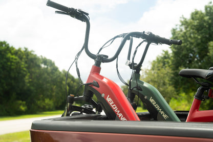 velowave_Two Pony electric bicycles mounted on a vehicle with trees in the background