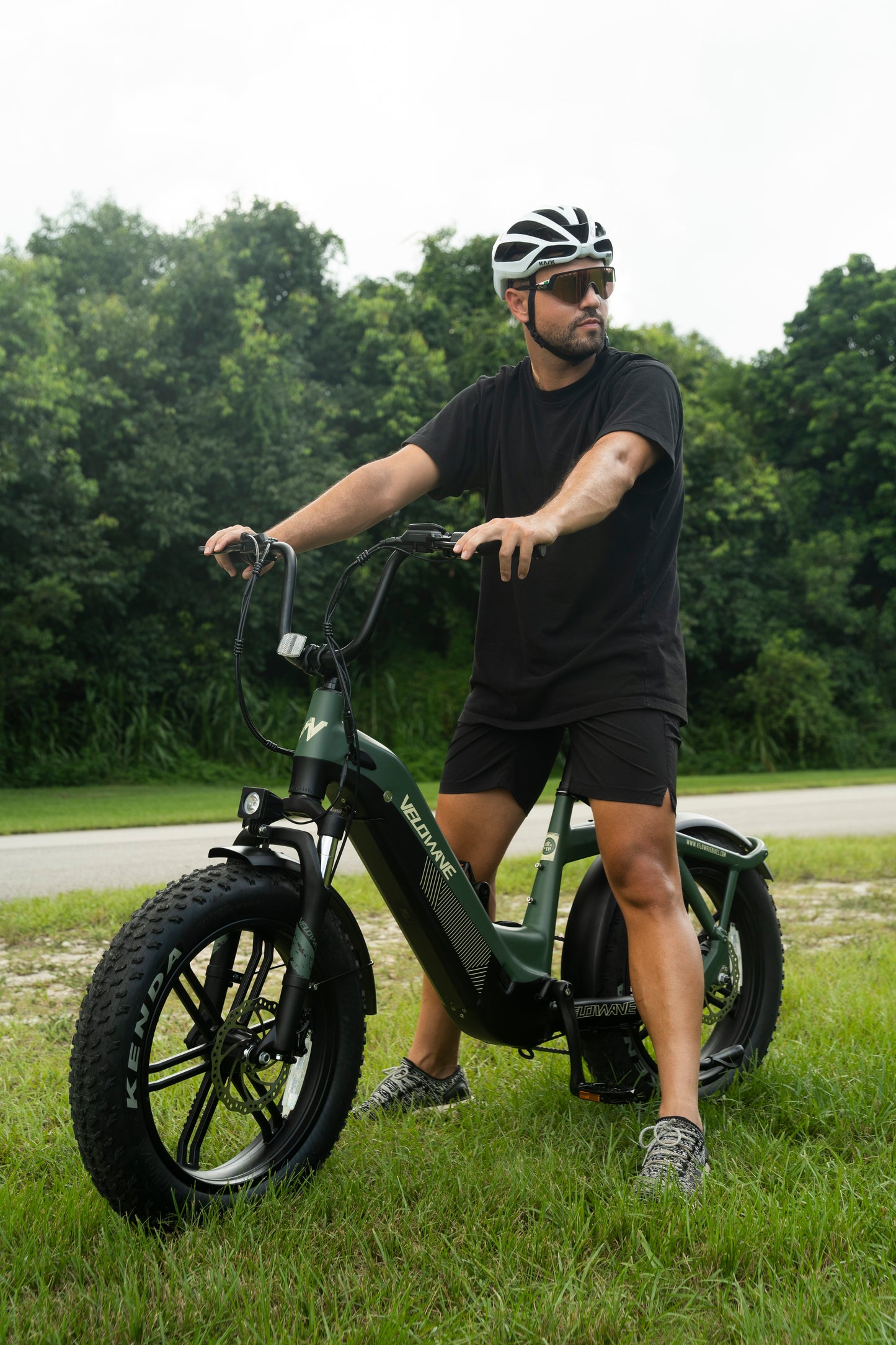 velowave_Man riding the Pony electric bike outdoors with trees in the background